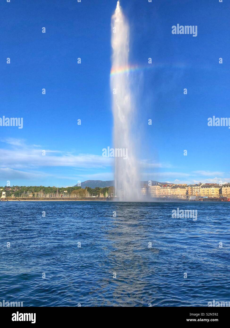 Eine der längsten Wasserfontänen in die Welt Genfer Wasserfontäne Jet d'eau", mit einem kleinen Regenbogen - Smartphone-aufgenommenes Stockfoto