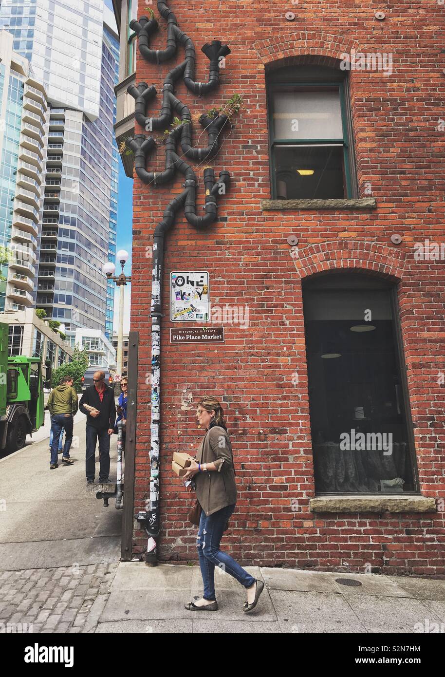 Gebäudewand mit rtistic Ablaufleitung am Pike Place Market, Seattle, Washington, USA. Mai 17, 2019. - Smartphone-aufgenommenes Stockfoto