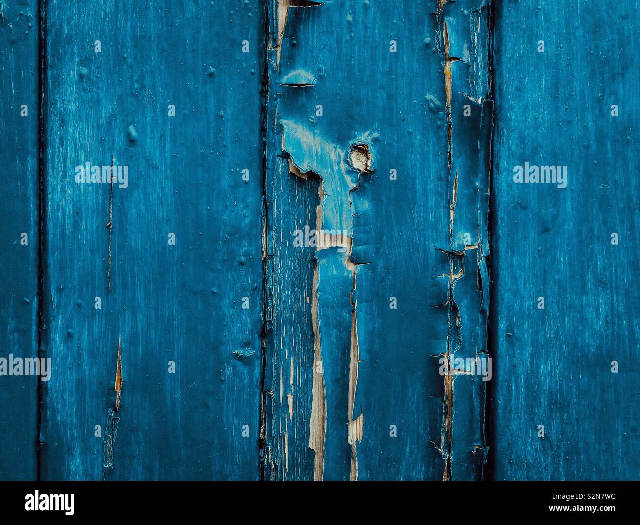 Risse und Schälen der blauen Farbe auf alte Holztür. Stockfoto