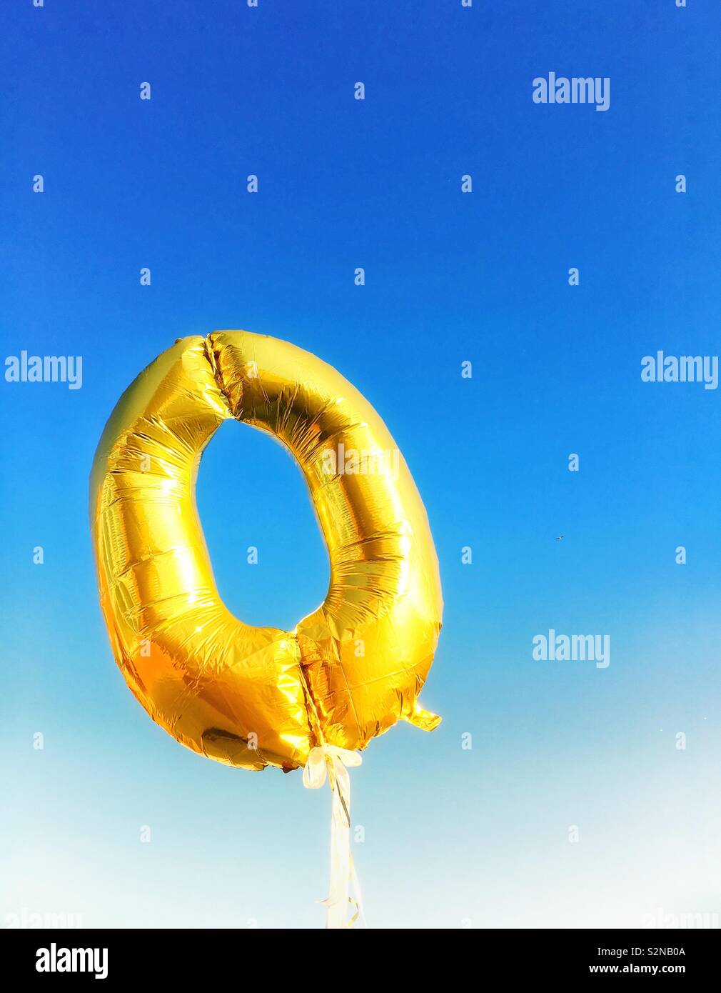 Golden runden Ballon (Null) floating gegen einen strahlend blauen Himmel Stockfoto