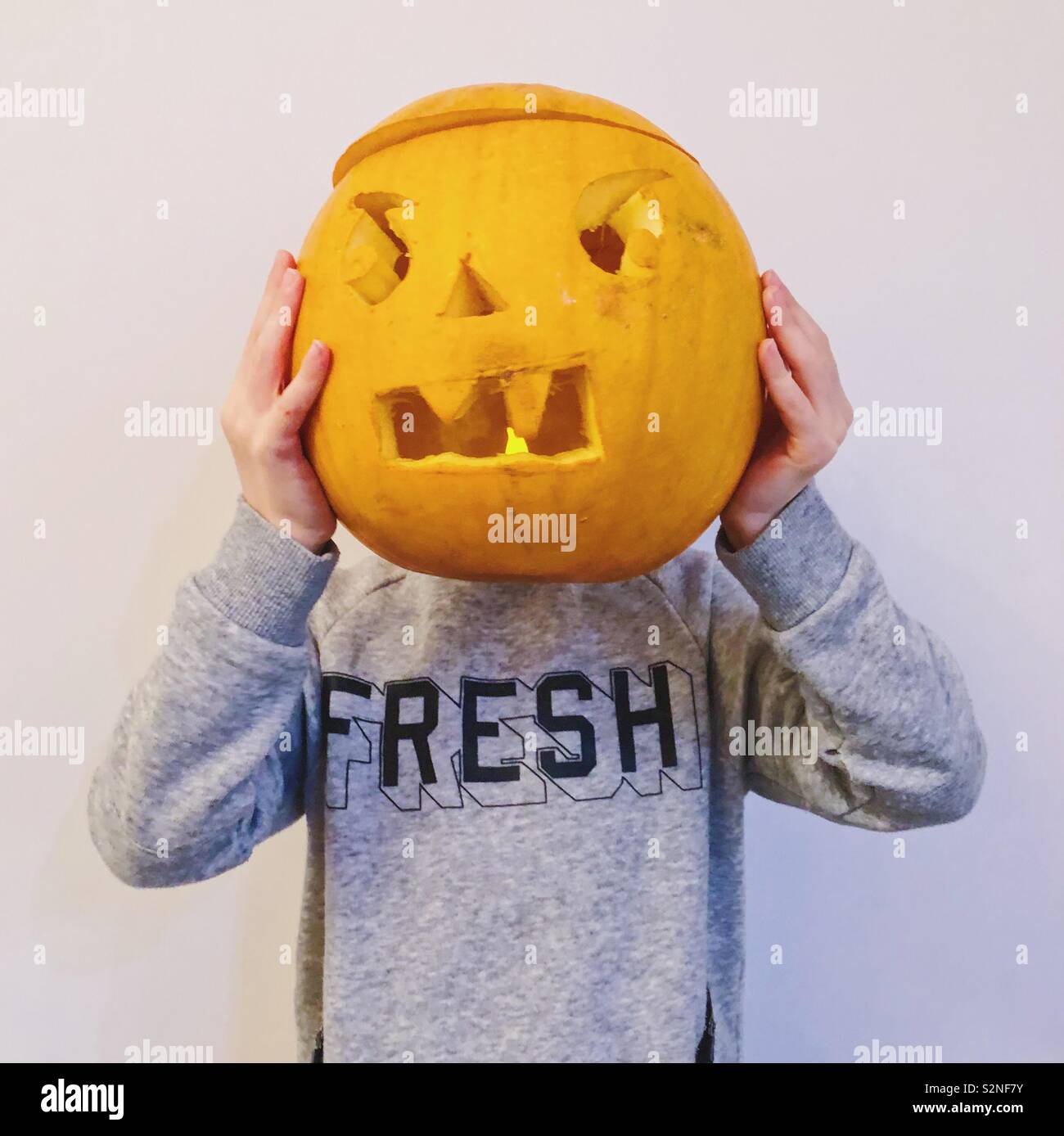 Junge mit Halloween Kürbis auf dem Kopf. Stockfoto