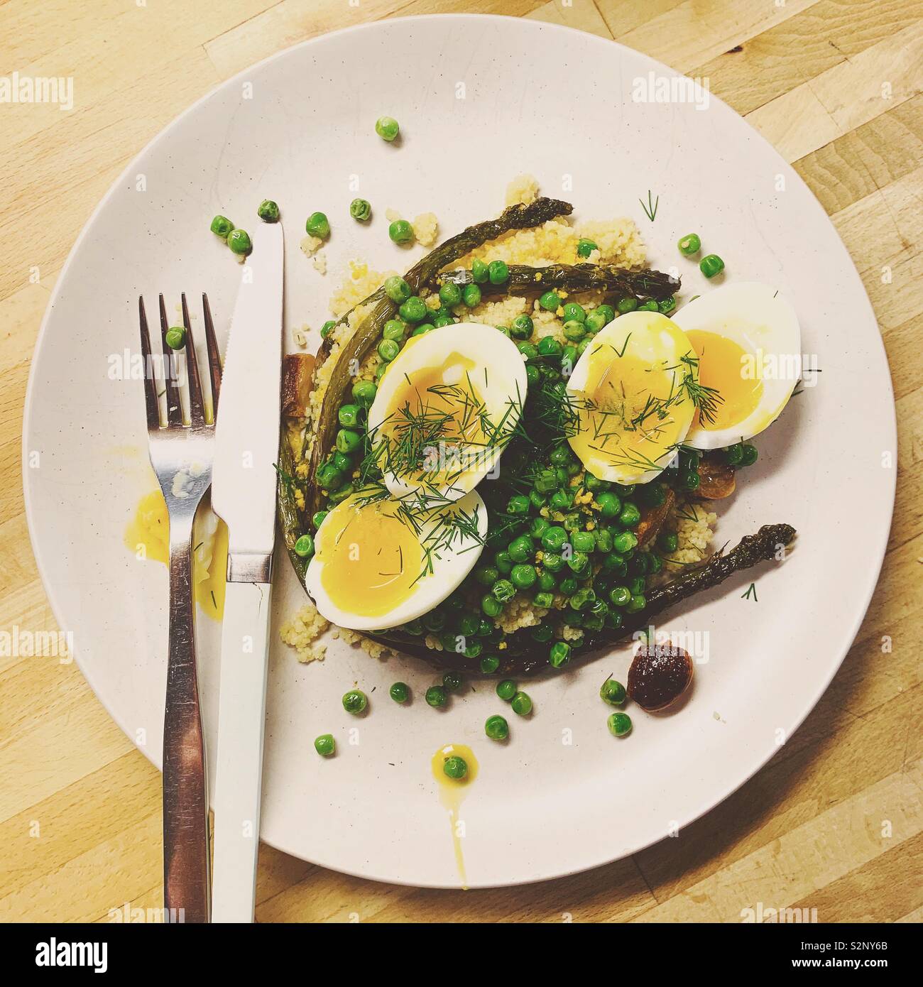 Spargel, Erbsen und weich gekochte Eier mit Couscous und Dill. Stockfoto