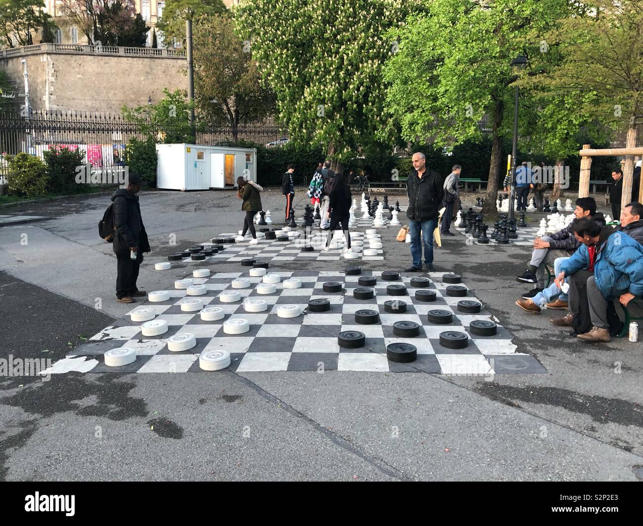 Ältere Männer spielen Entwürfe oder Steine auf großen Schachbrett Spiel auf die Bastionen park Boden - Genf Schweiz - Smartphone-aufgenommenes Stockfoto