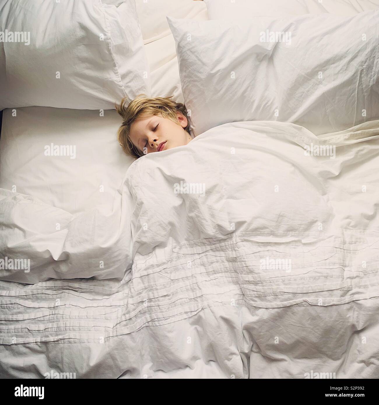 Kleiner Junge schlafen im Bett der Eltern Stockfoto