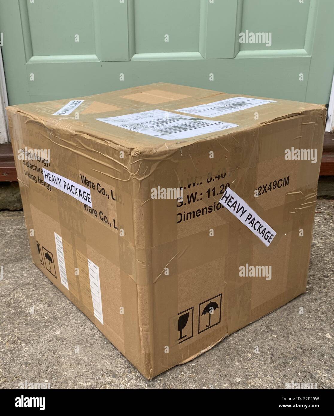 Großes Paket mit schweren Paket an der grünen Tür Stockfotografie - Alamy