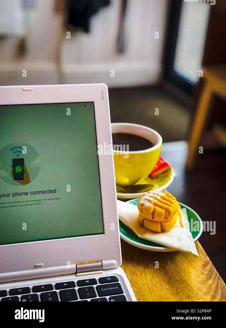 Kaffee, Kuchen und Computer. - Smartphone-aufgenommenes Stockfoto