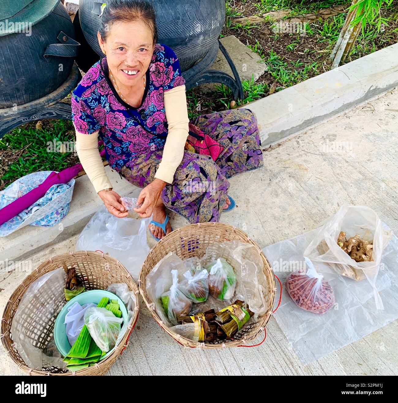 Eine thailändische Frau Snacks außerhalb einer Schule im Norden von Thailand zu verkaufen. - Smartphone-aufgenommenes Stockfoto