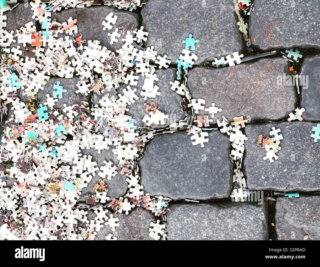 Puzzle Stücke auf einer gepflasterten Straße - Smartphone-aufgenommenes Stockfoto