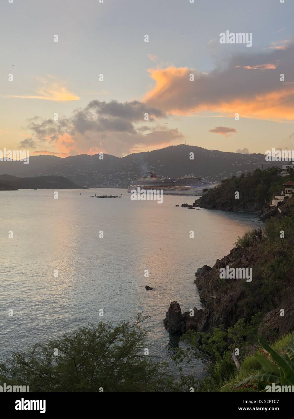 Ein Schiff verlässt den Hafen von Charlotte Amalie auf der Insel St. Thomas in den U.S. Virgin Islands bei Sonnenuntergang. - Smartphone-aufgenommenes Stockfoto