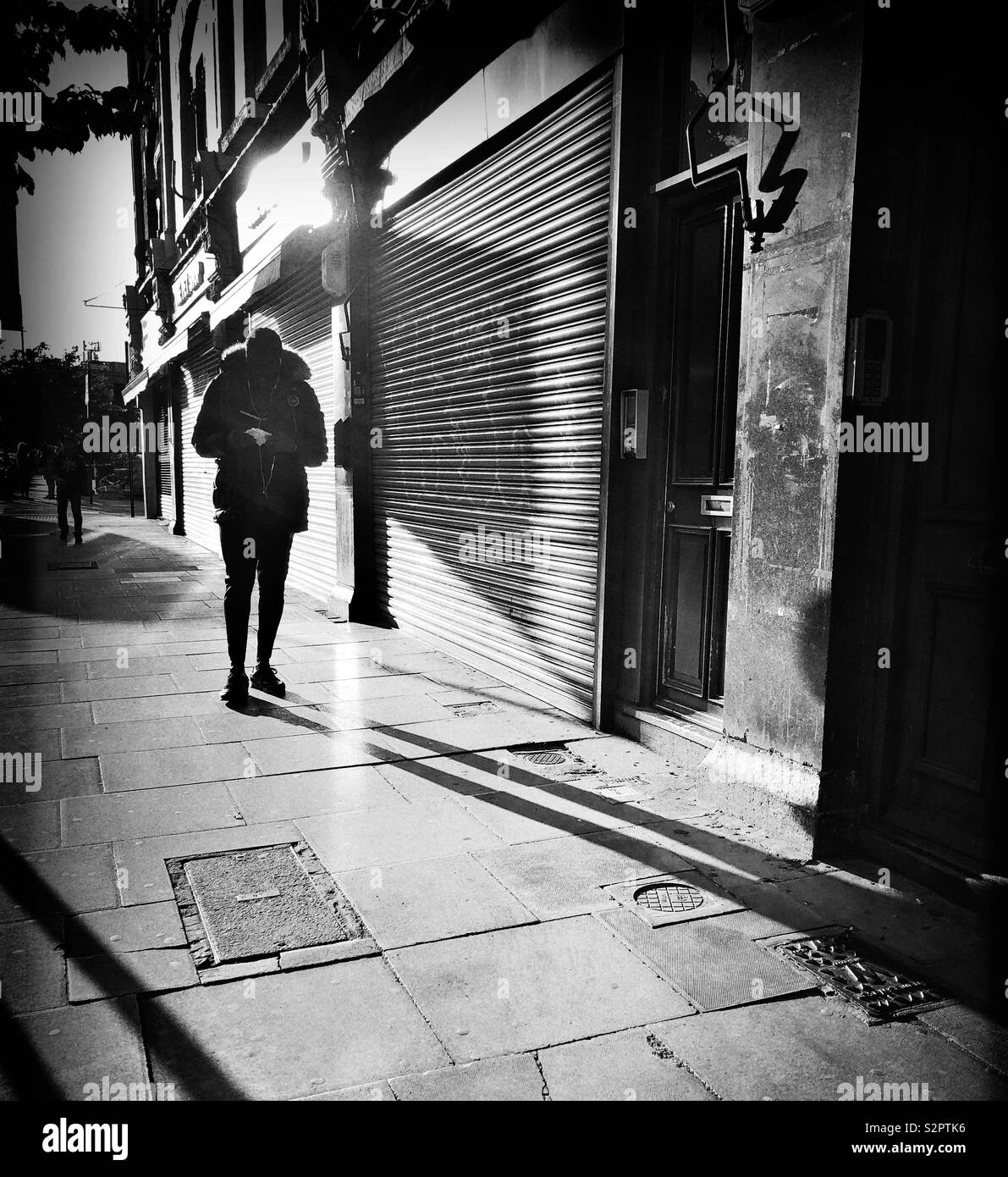 Man Walking in dramatischen beleuchtete Straße - Smartphone-aufgenommenes Stockfoto