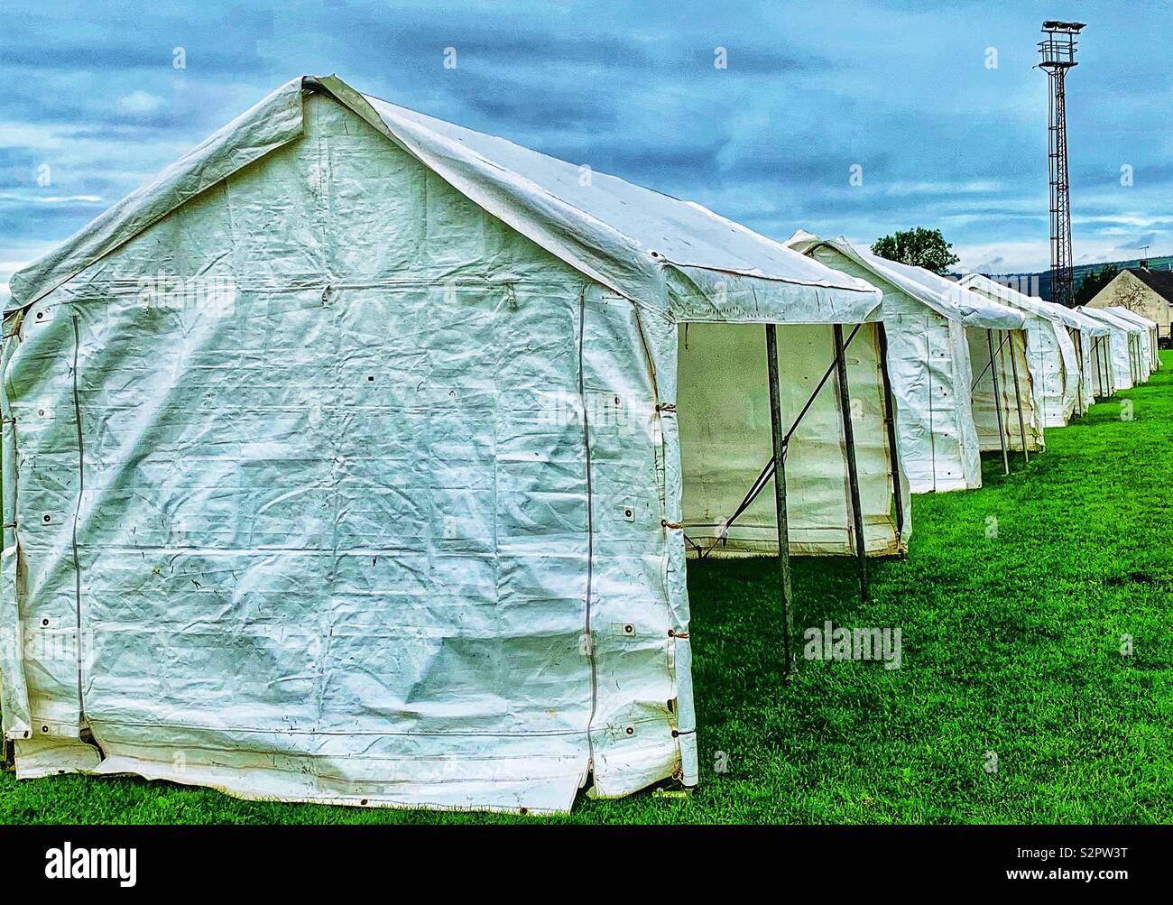 Reihe von leeren weißen Festzelten in Sportplatz mit Flutlicht Stockfoto