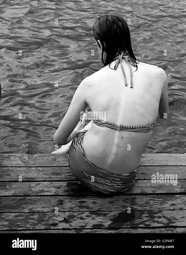 Eine junge Frau sitzt auf einem Dock in Santiago Atitlan Guatemala. Stockfoto