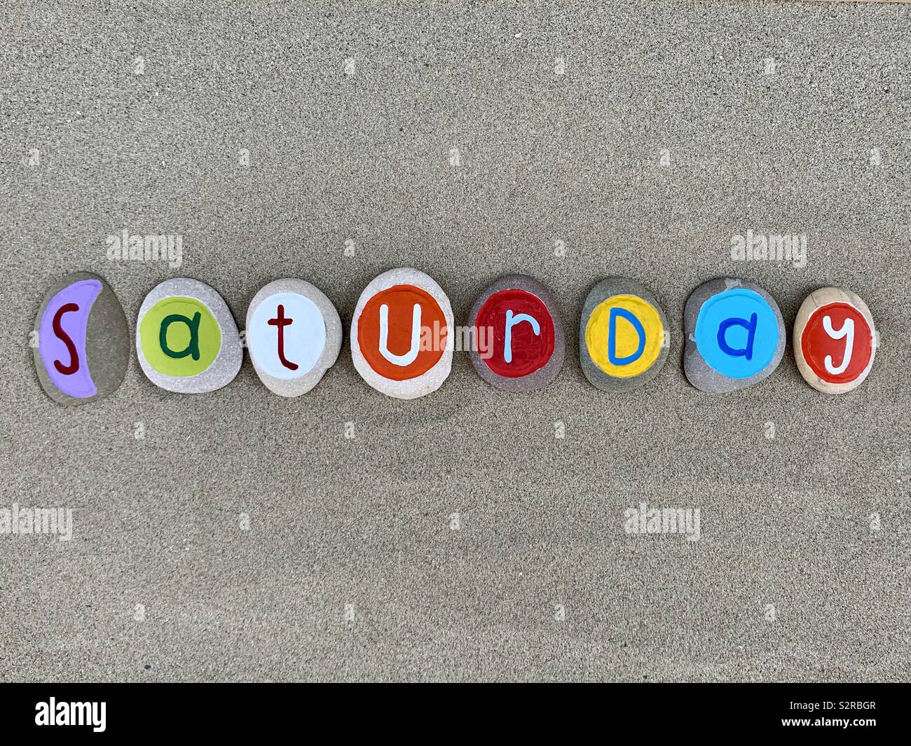 Samstag, Sixt Tag der Woche zusammen mit farbigen Kiesel Briefe über Strand sand - Smartphone-aufgenommenes Stockfoto