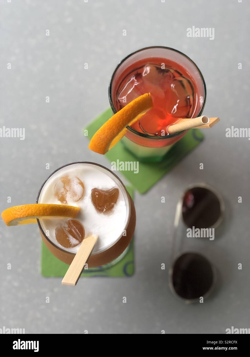 Zwei alkoholfreie Cocktails auf grauem Hintergrund mit Sonnenbrille im Weichzeichner Stockfoto