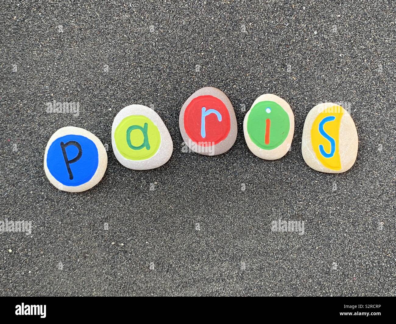 Paris, Souvenir der französischen Stadt mit farbigen Steinen über schwarzen vulkanischen Sand Stockfoto