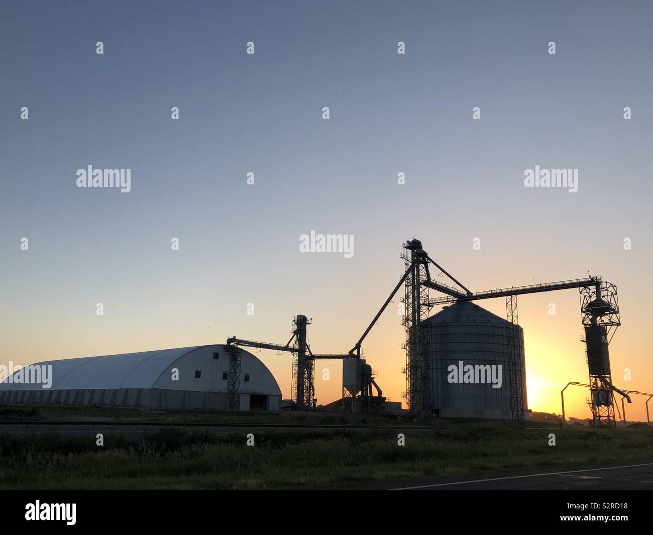 Getreide und Futtermittel Mühle an der Arbeit bei Sonnenaufgang in der Heartland Stockfoto