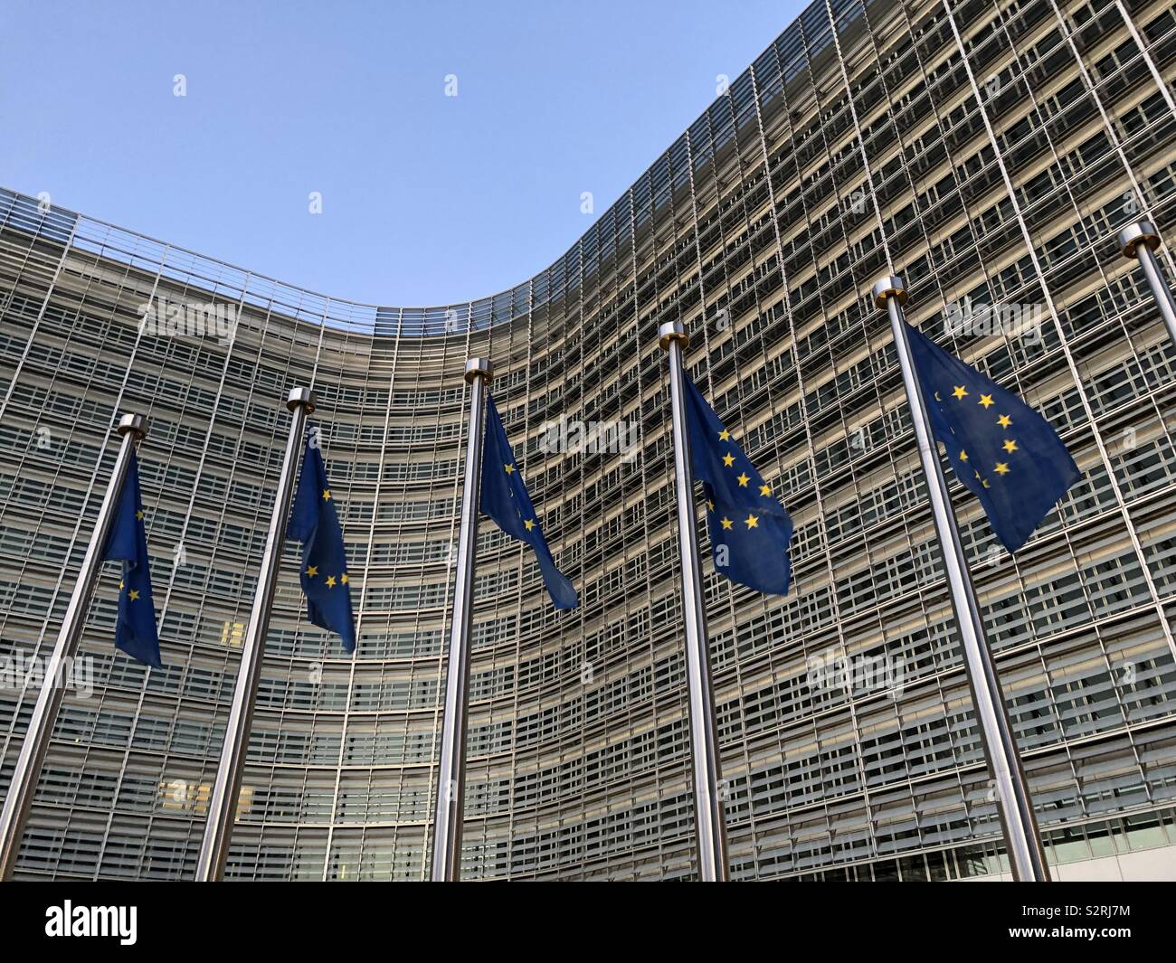 Europäische Kommission, Berlaymont Gebäude im Abendlicht mit EU-Flaggen vor, Brüssel, Belgien. Stockfoto