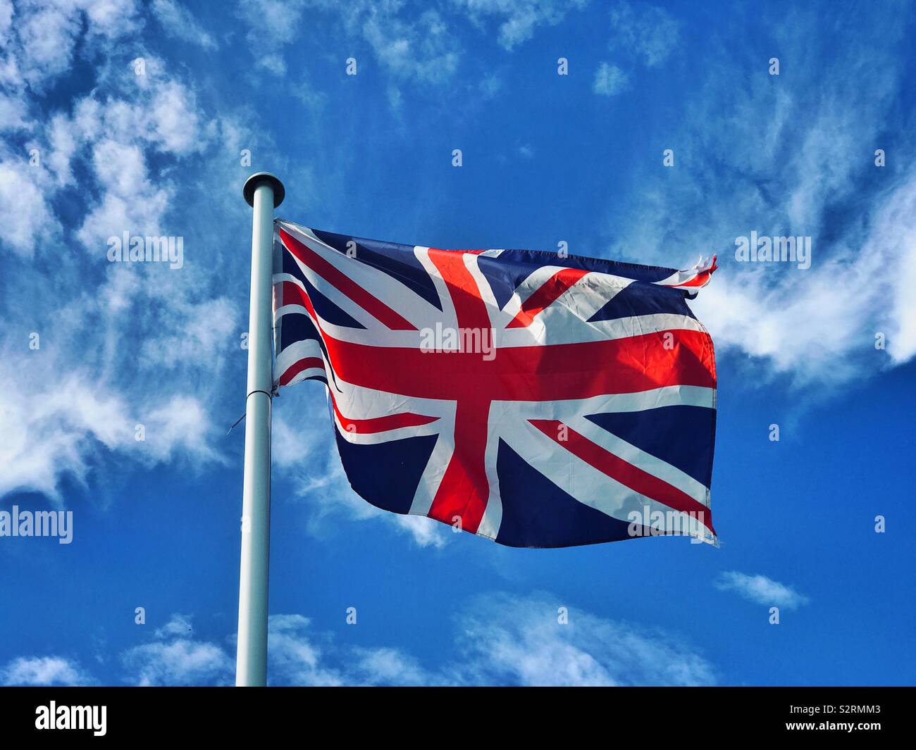 Der Union Jack Flagge stolz Fliegen an einem Sommertag. Das rote Kreuz von St. George ist deutlich sichtbar in der Mitte der Flagge. Foto - © COLIN HOSKINS. - Smartphone-aufgenommenes Stockfoto