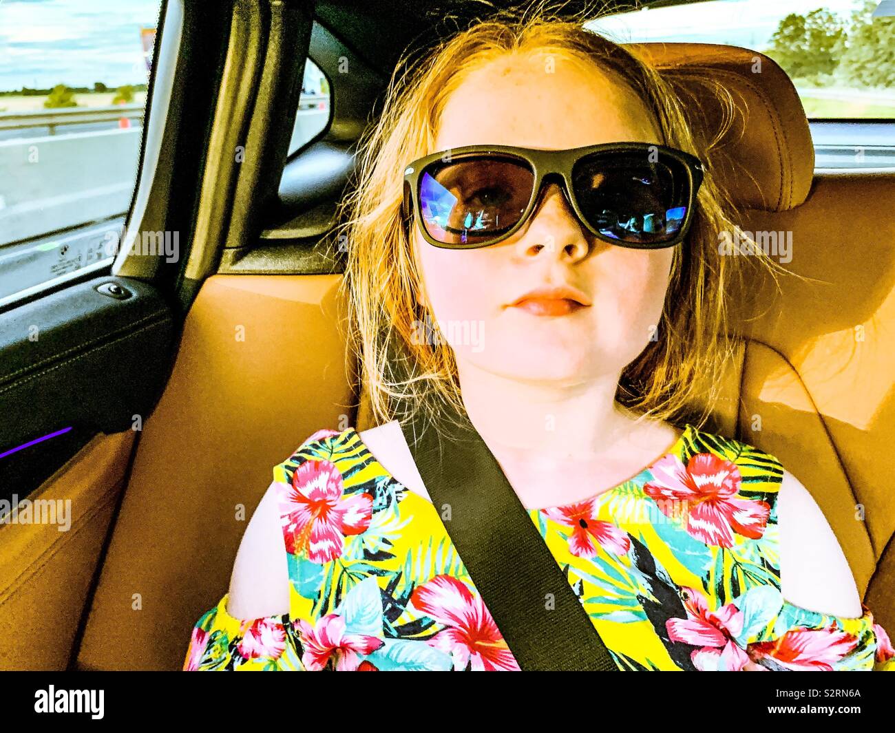 Junge 9 Jahre altes Mädchen im Auto tragen Sonnenbrillen Stockfoto