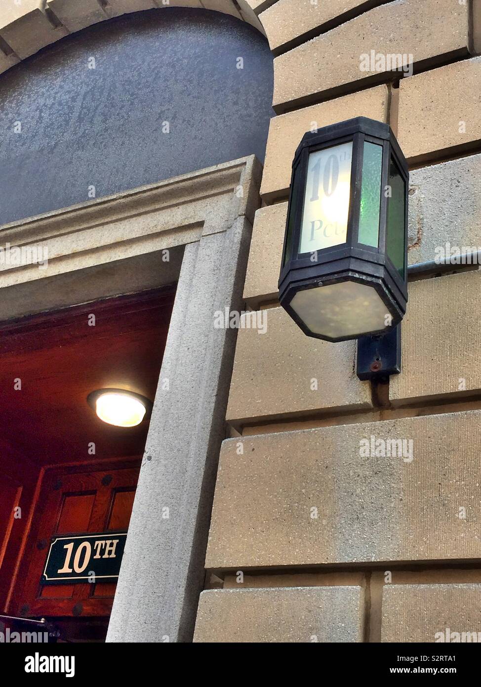 Die Haupteingangstür und antike Lampe an der NYPD 10 Revier Station House in Chelsea, New York City, USA - Smartphone-aufgenommenes Stockfoto