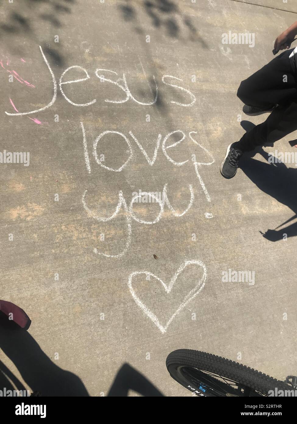 Graffiti gefunden auf dem Zement Boden im Park mit den Worten von Jesus sie liebt. Liebe und Ermutigung Stockfoto