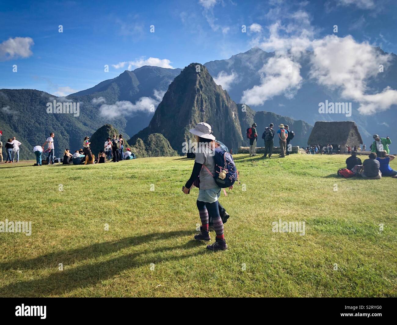 Besucher und Guides sammeln kurz nach Sonnenaufgang am Machu Picchu Machu Picchu Inka Ruinen mit dem Gipfel des Huayna Picchu Wayna Pikchu im Hintergrund. Stockfoto