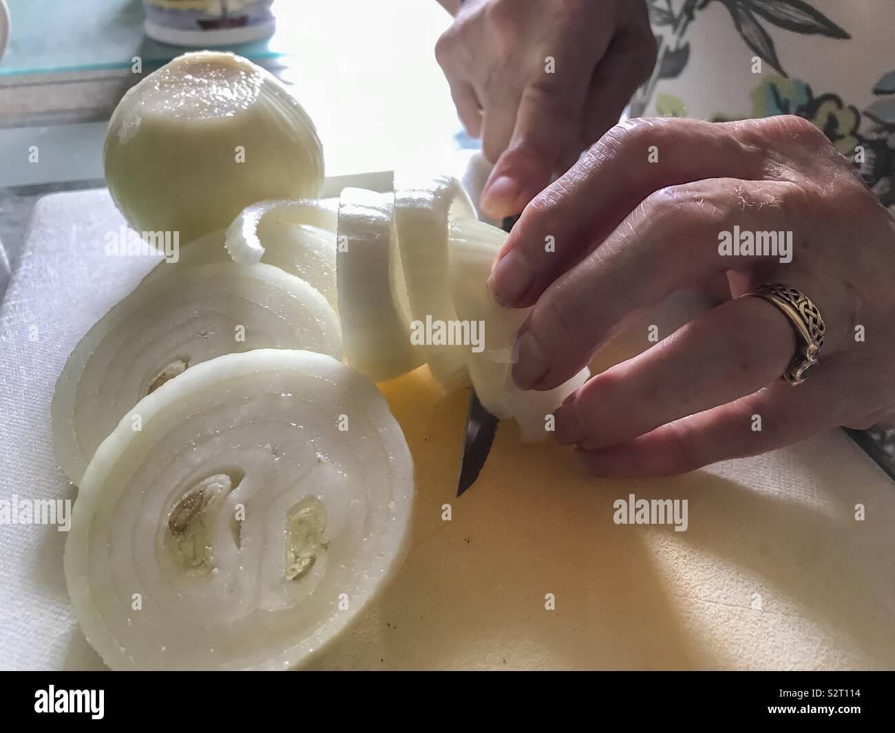 Nahaufnahme einer Dame schneiden Zwiebeln. - Smartphone-aufgenommenes Stockfoto