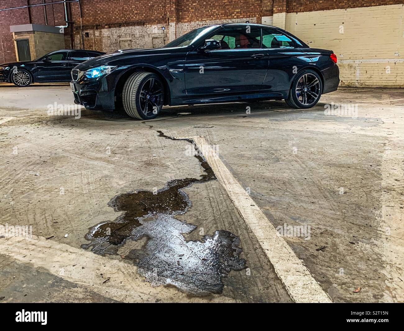 Öl leckt aus einem schwarzen BMW M4 Stockfoto
