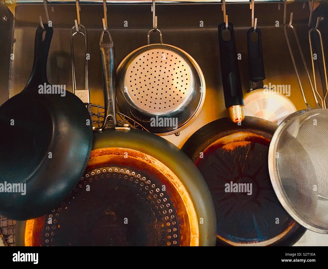 Töpfe Pfannen und Siebe auf aufhängeschiene Stockfoto