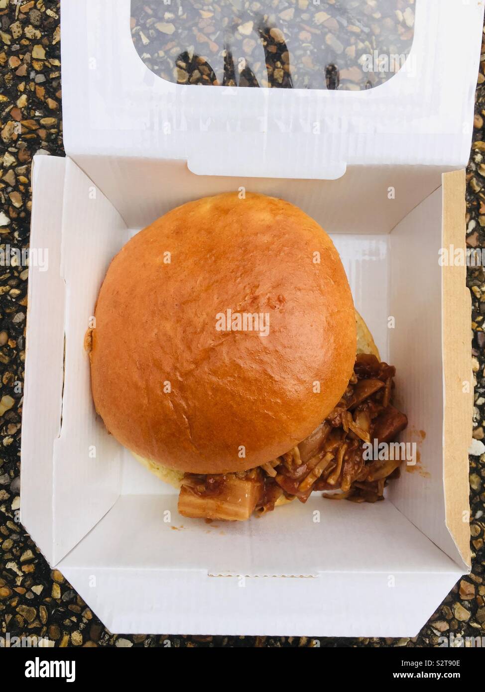 Eine vegane Jackfrucht in einem Brioche-Brötchen in einer Pappschachtel Stockfoto