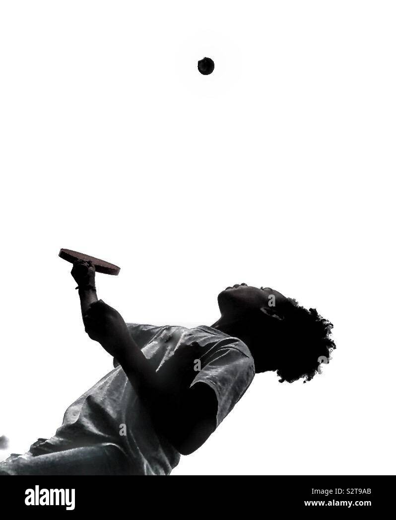 Ein Kind, das mit einem Schläger und Ball. - Smartphone-aufgenommenes Stockfoto