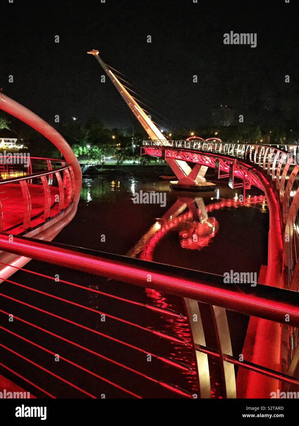 Die Darul Hana Brücke, wodurch Fußgänger den Sarawak River von Kuching Waterfront Revier zu den Staat Legislative Assembly Building, Sarawak, Malaysia, mit Flutlicht in der Nacht Kreuz Stockfoto