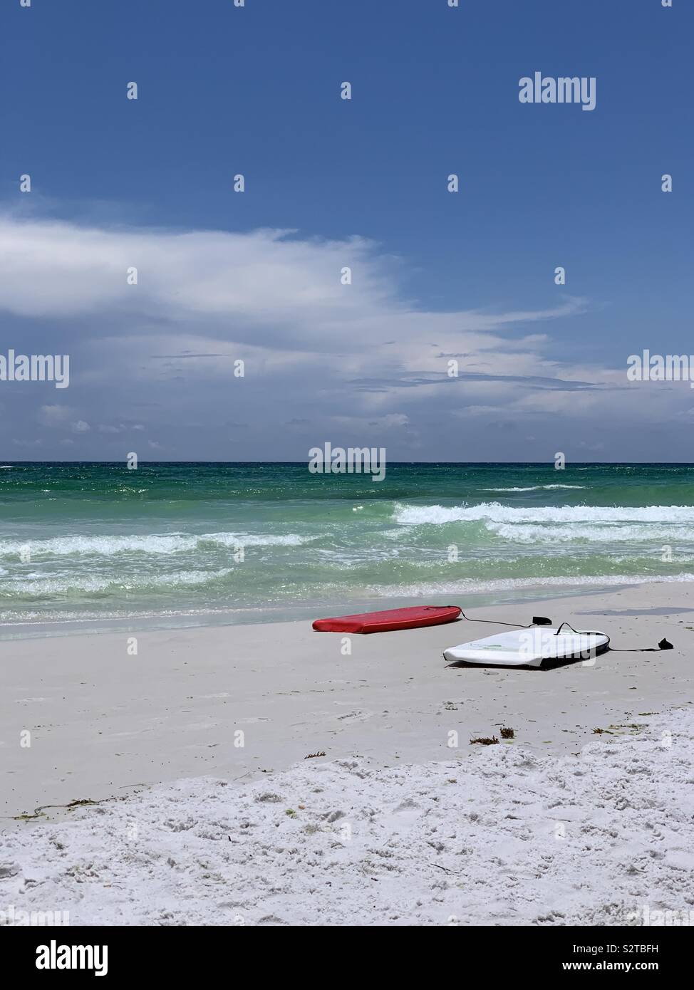 Rote und weiße Surfbretter auf weißen Sandstrand mit Blick auf den Golf von Mexiko smaragdgrünen Wasser und blauer Himmel Stockfoto