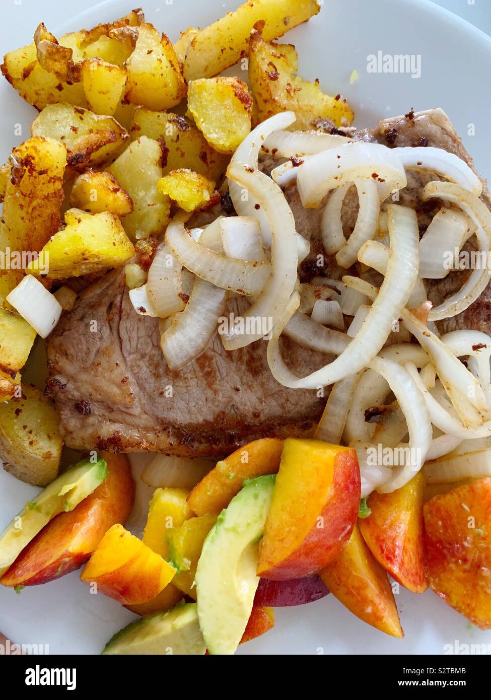 Steak mit Zwiebeln und Pommes Frites - Smartphone-aufgenommenes Stockfoto