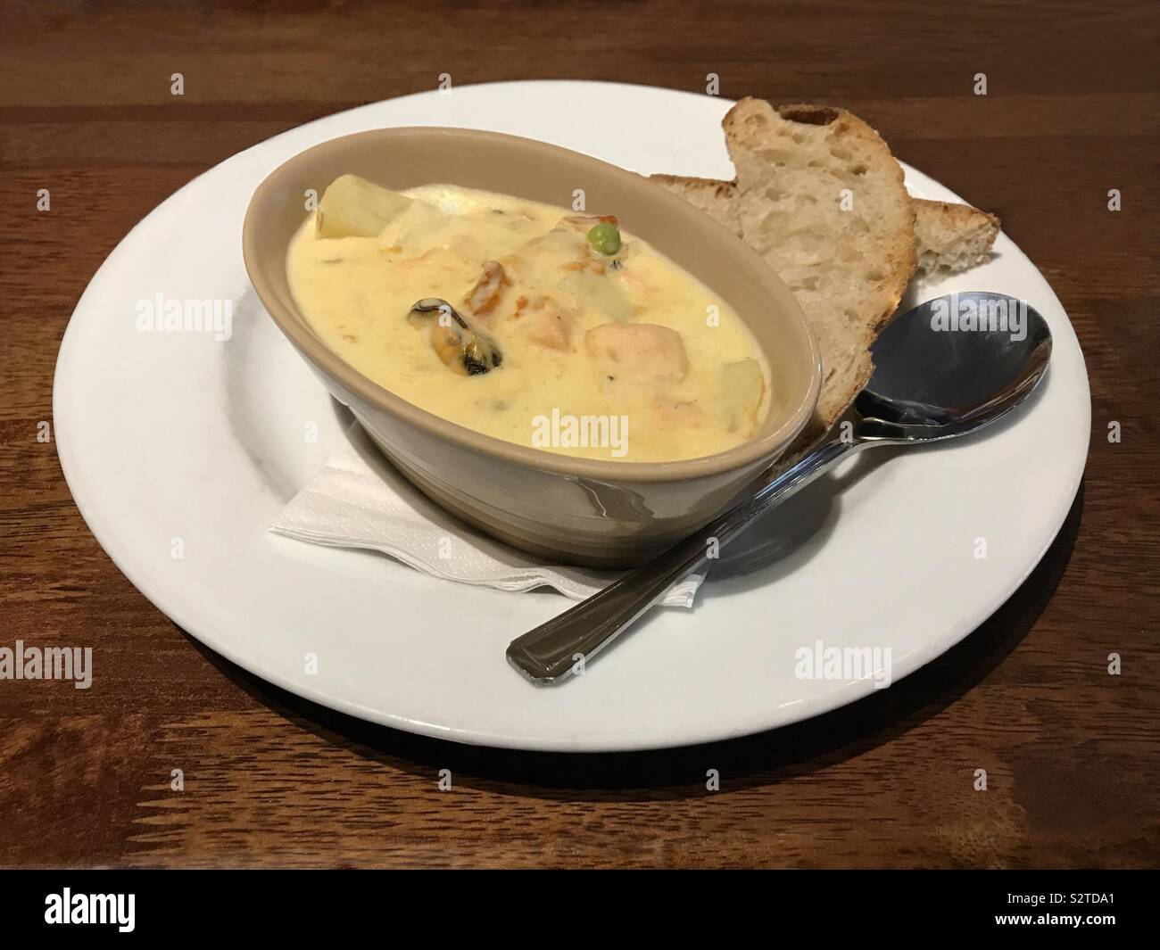 Cullen Skink traditionelle schottische Suppe gezeigt, mit weißen Fisch, Kartoffeln, Zwiebeln, Milch, und ist in dieser Version, Muscheln. Brot ist auf der Seite gedient. Stockfoto