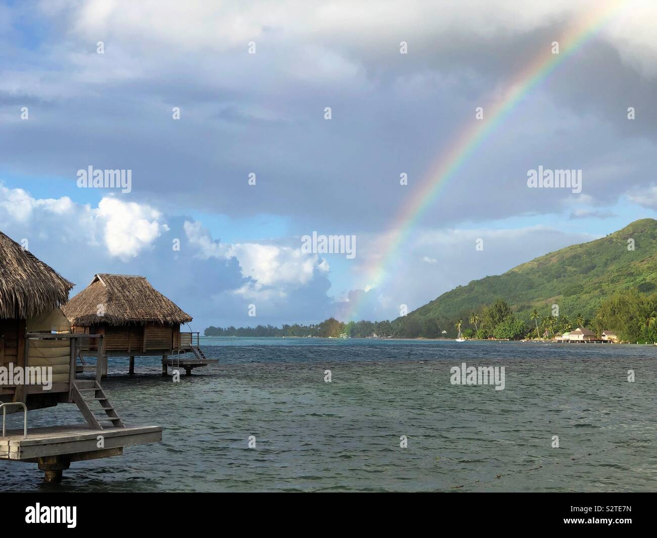 Ein Regenbogen über der Lagune während einer Regendusche in einem Resort auf Moorea Französisch-Polynesien. - Smartphone-aufgenommenes Stockfoto