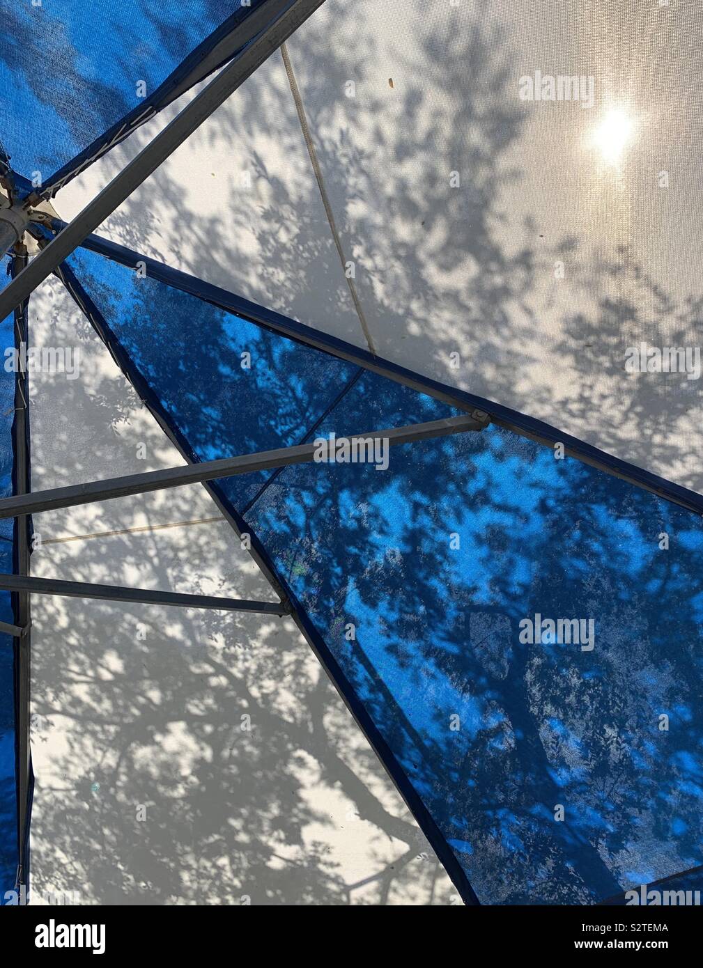 Zusammenfassung von outdoor Regenschirm mit Baum Schatten auf Gewebe und Sun Stockfoto