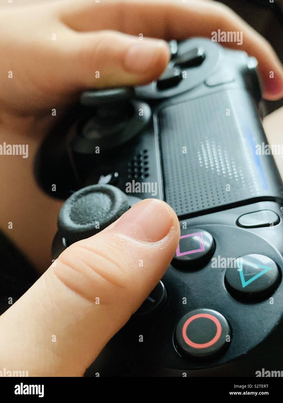 Kinder spielen PlayStation. Nahaufnahme des Konsolencontrollers für Videospiele. Google Stadia und Apple Arcade. Einen PlayStation -Controller halten Stockfoto