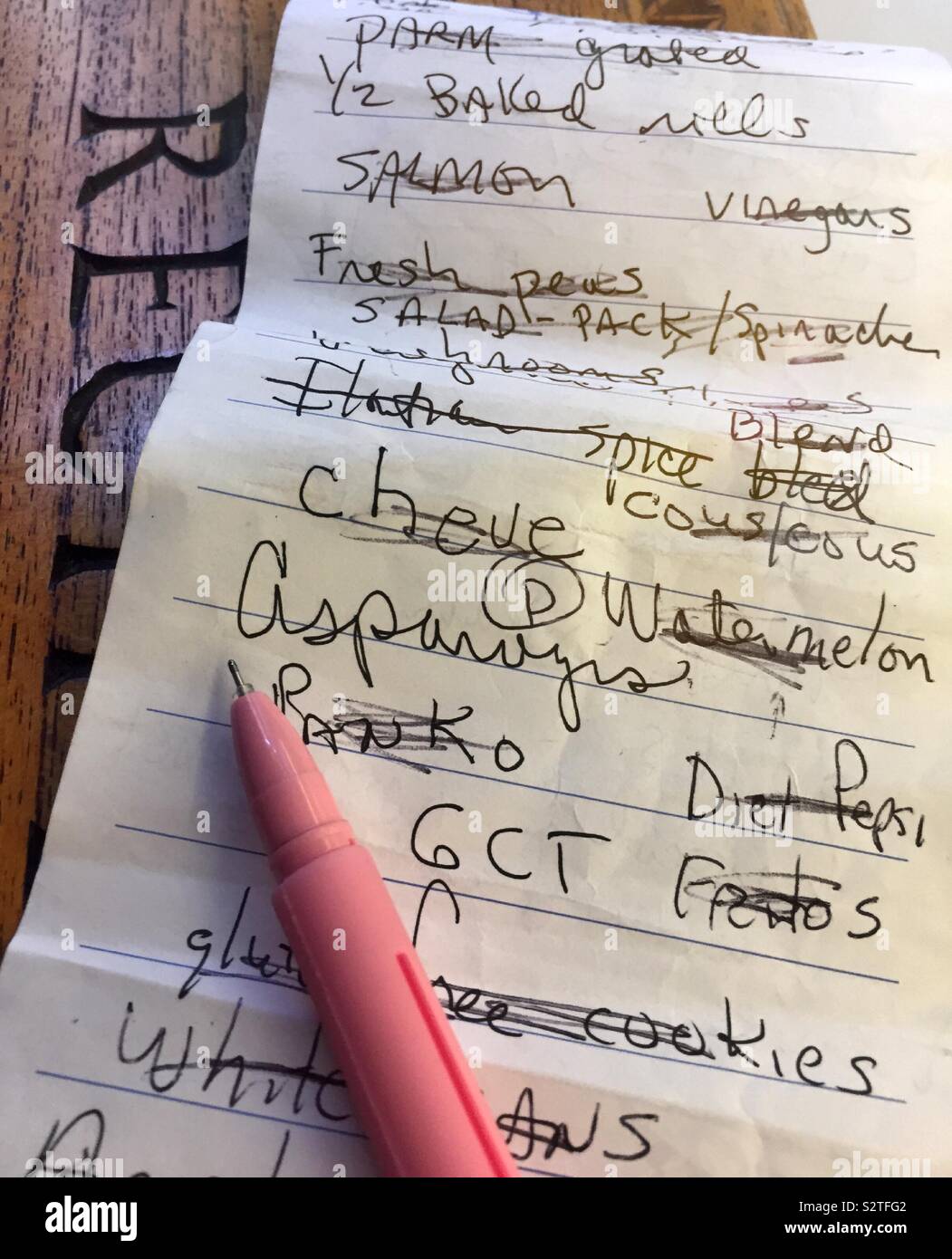 Einkaufszettel und Kugelschreiber auf dem Küchentisch, USA - Smartphone-aufgenommenes Stockfoto
