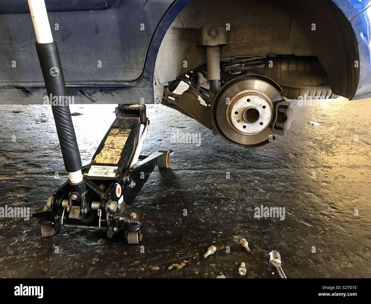 Ein Auto ein Auto mit einem Rad zum Reifenwechsel entfernt. - Smartphone-aufgenommenes Stockfoto