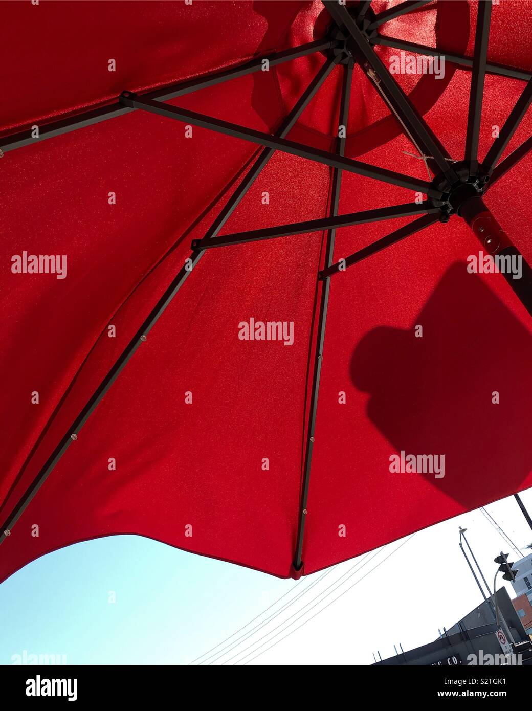 Versteckt unter einem Regenschirm Mitte tag Hitze in Los Angeles zu vermeiden. Stockfoto