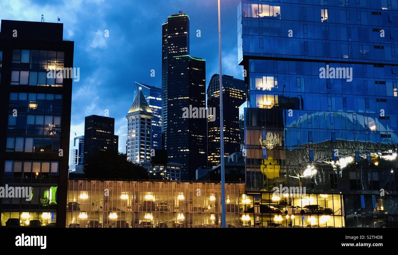Downtown Seattle in der Dämmerung mit Reflexionen des Stadions entlang mit Blick auf den legendären Smith Tower und Columbia Center - das höchste Gebäude der Stadt. Stockfoto