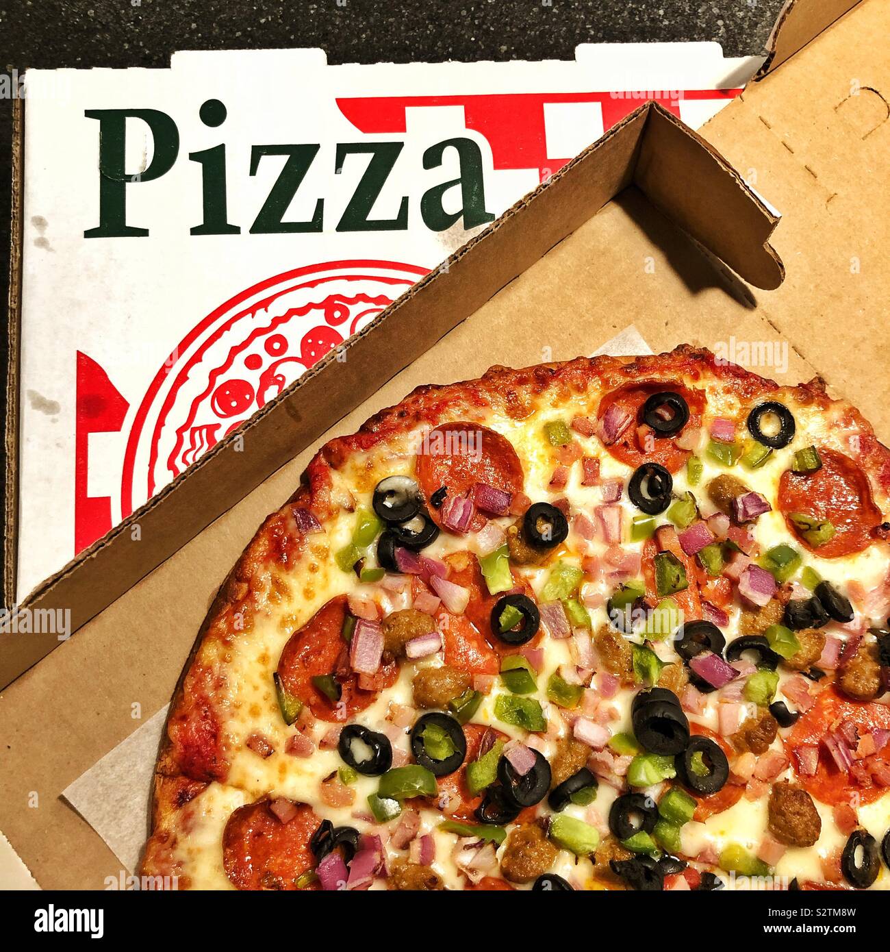 Eine offene pizza box zeigt eine Pizza mit Belag auf der anderen geschlossen pizza box Stockfoto