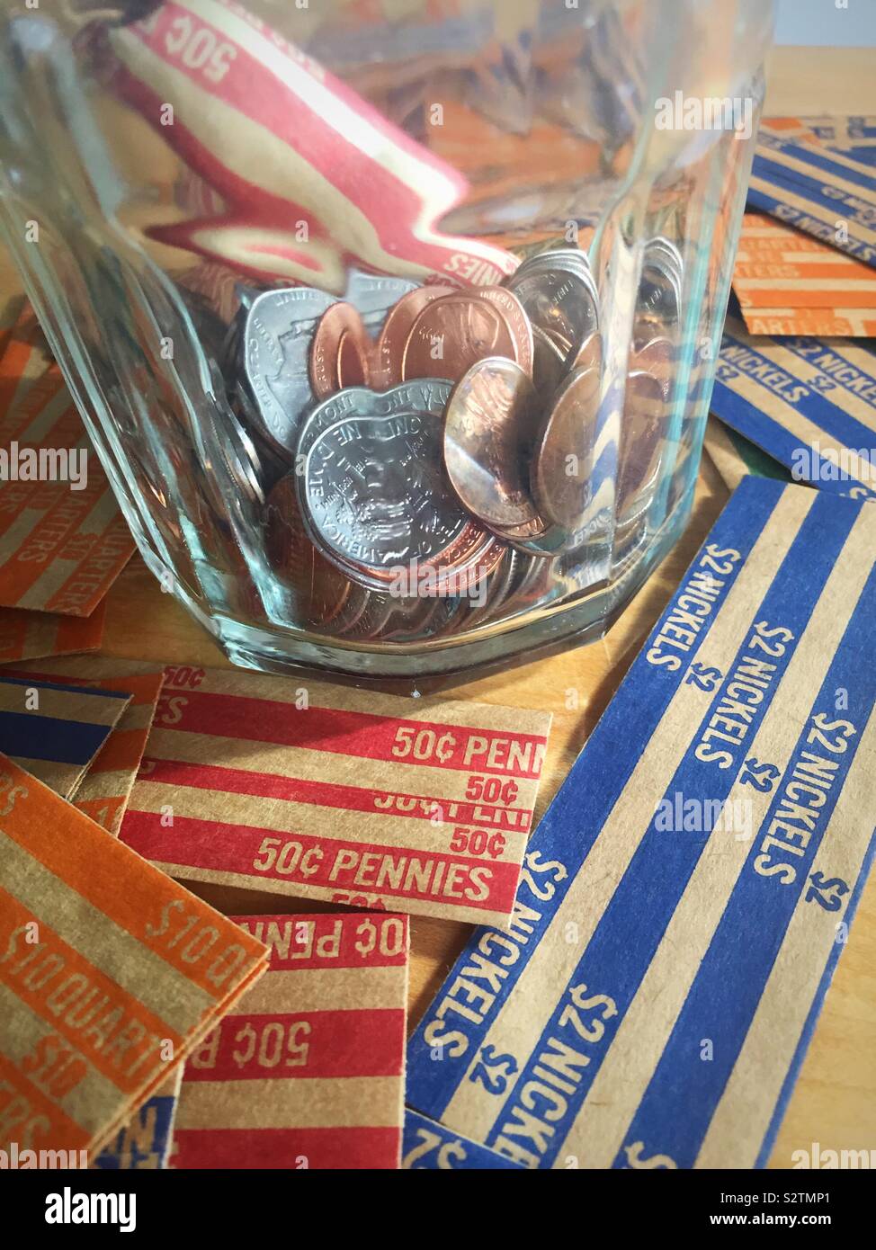 Glas Glas mit Loose Change gefüllt und wickelte Pennies auf coin Wrappers, USA - Smartphone-aufgenommenes Stockfoto