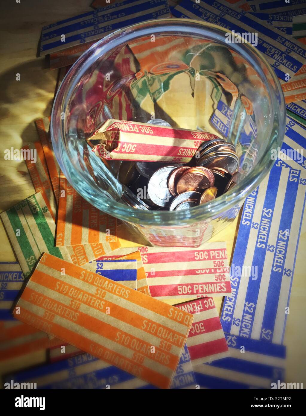 Glas Glas mit Loose Change gefüllt und wickelte Pennies auf Münze Wrapper close up, USA - Smartphone-aufgenommenes Stockfoto