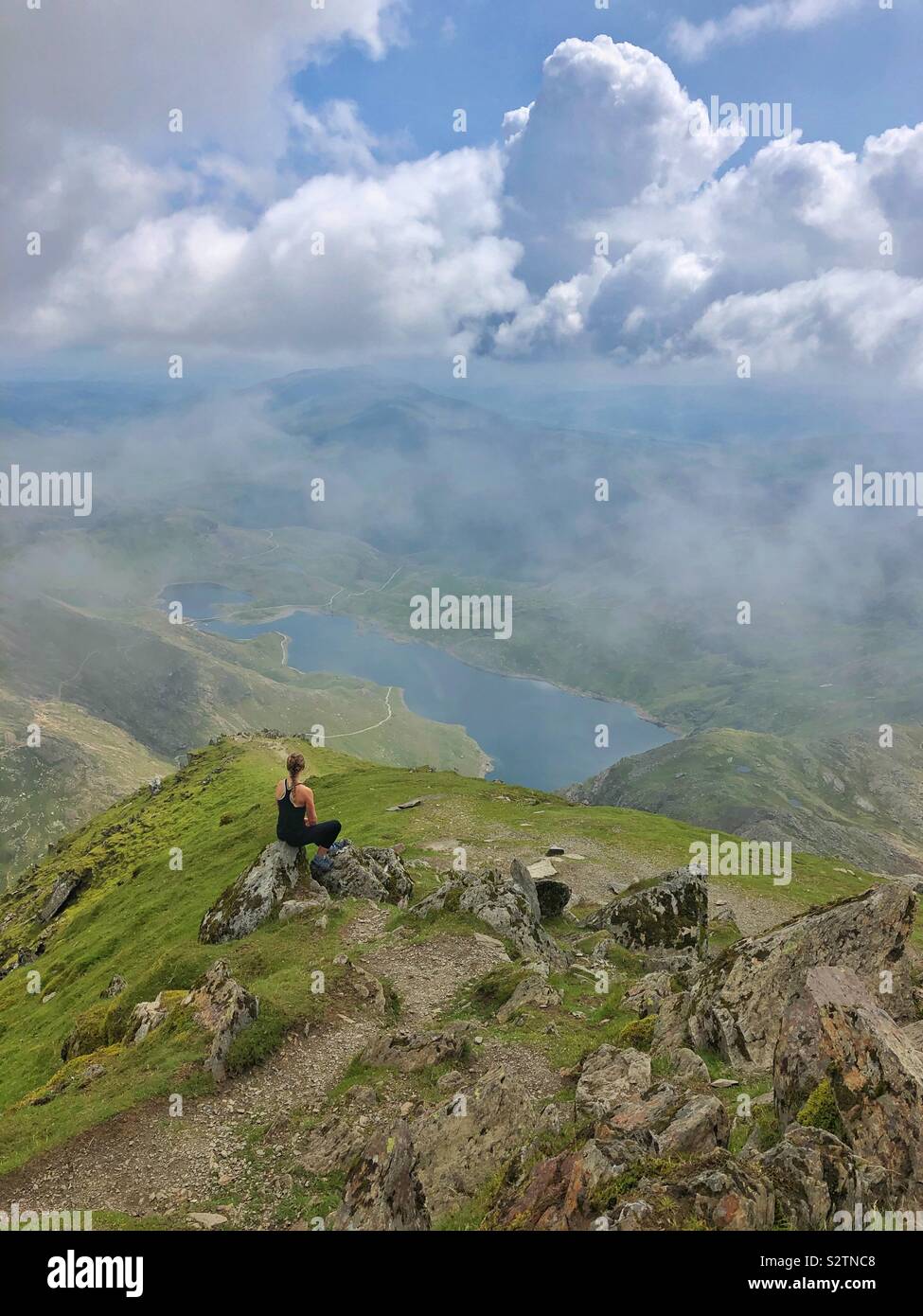 Junge Frau genießt die Aussicht vom Gipfel von Snowdon, Snowdonia (Eryri) Nationalpark, Nordwales. Stockfoto