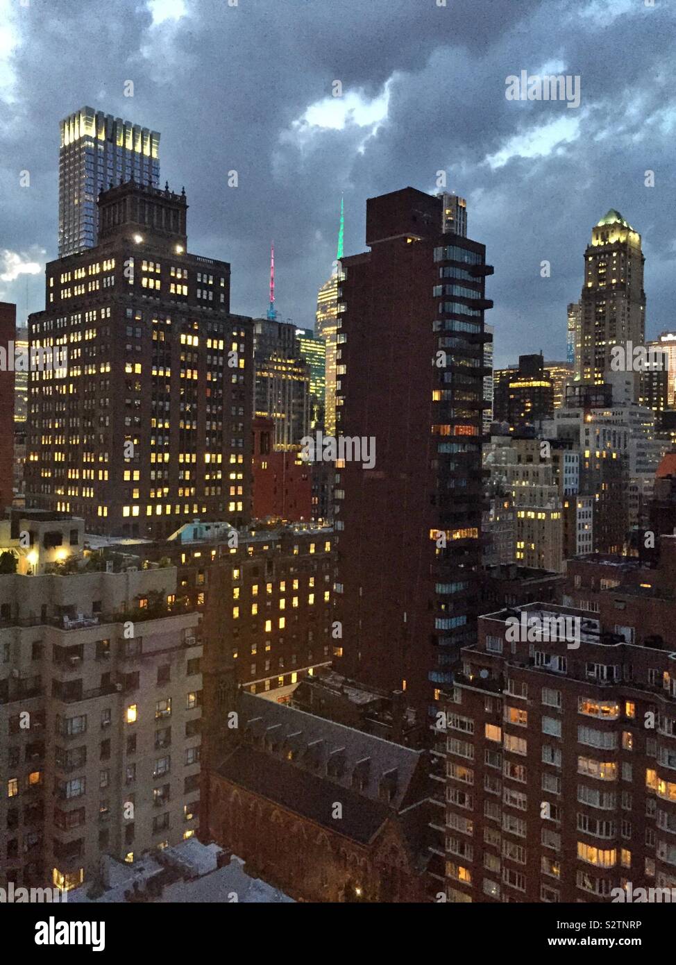 Wolkenkratzer in Midtown Manhattan in der Dämmerung an einem bewölkten Nacht, NEW YORK CITY, USA - Smartphone-aufgenommenes Stockfoto