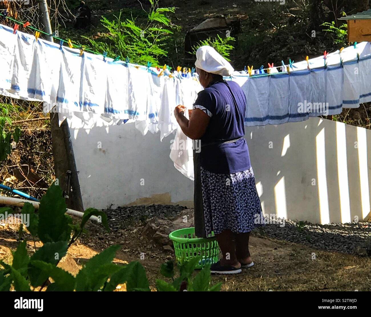 Lady Hanging Out eine Wäscheleine voller Handtücher auf der Insel Bequia - St. Vincent und die Grenadinen Stockfoto