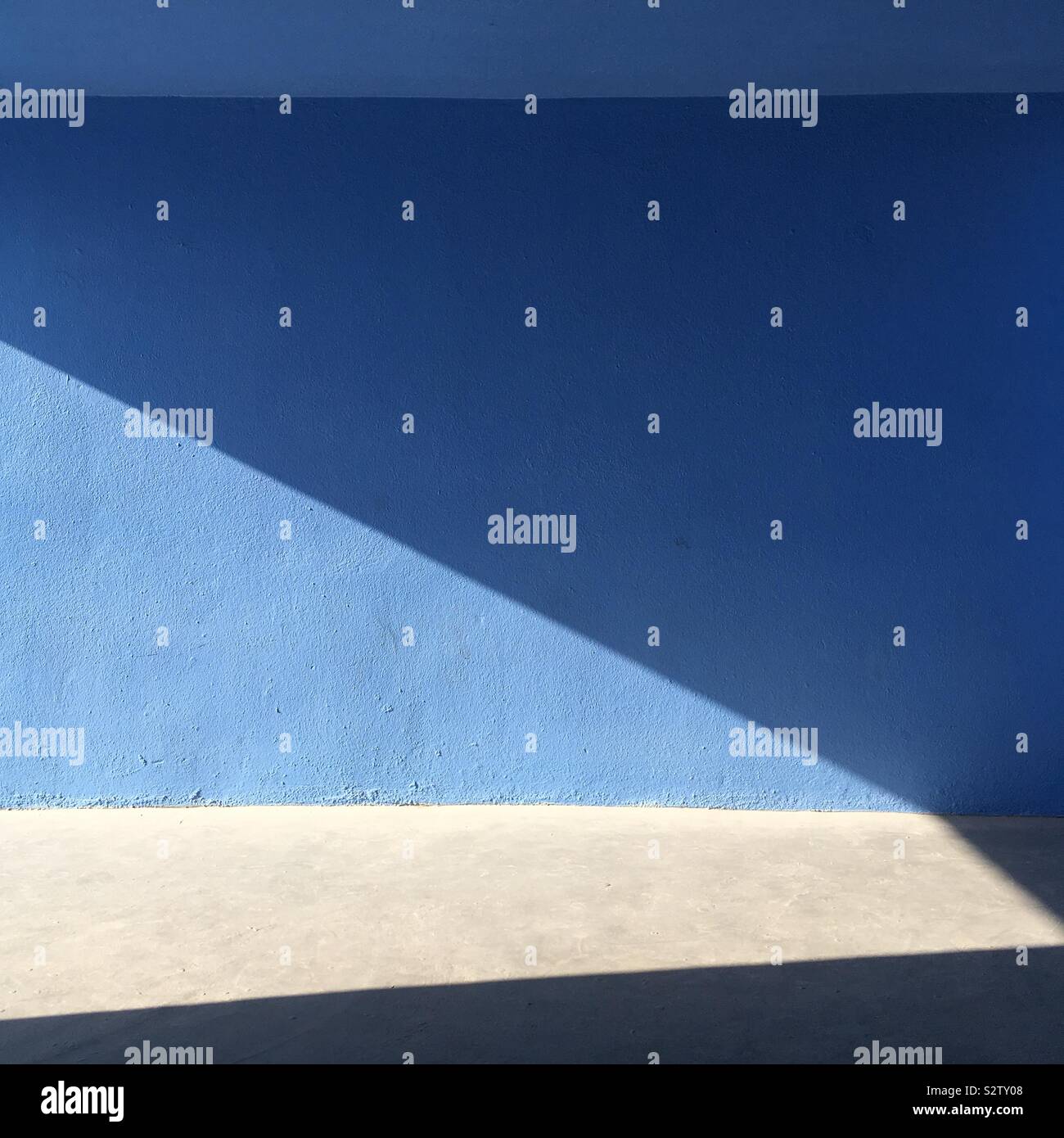 Leere blaue Wand Licht und Schatten mit weißen Boden Stockfoto