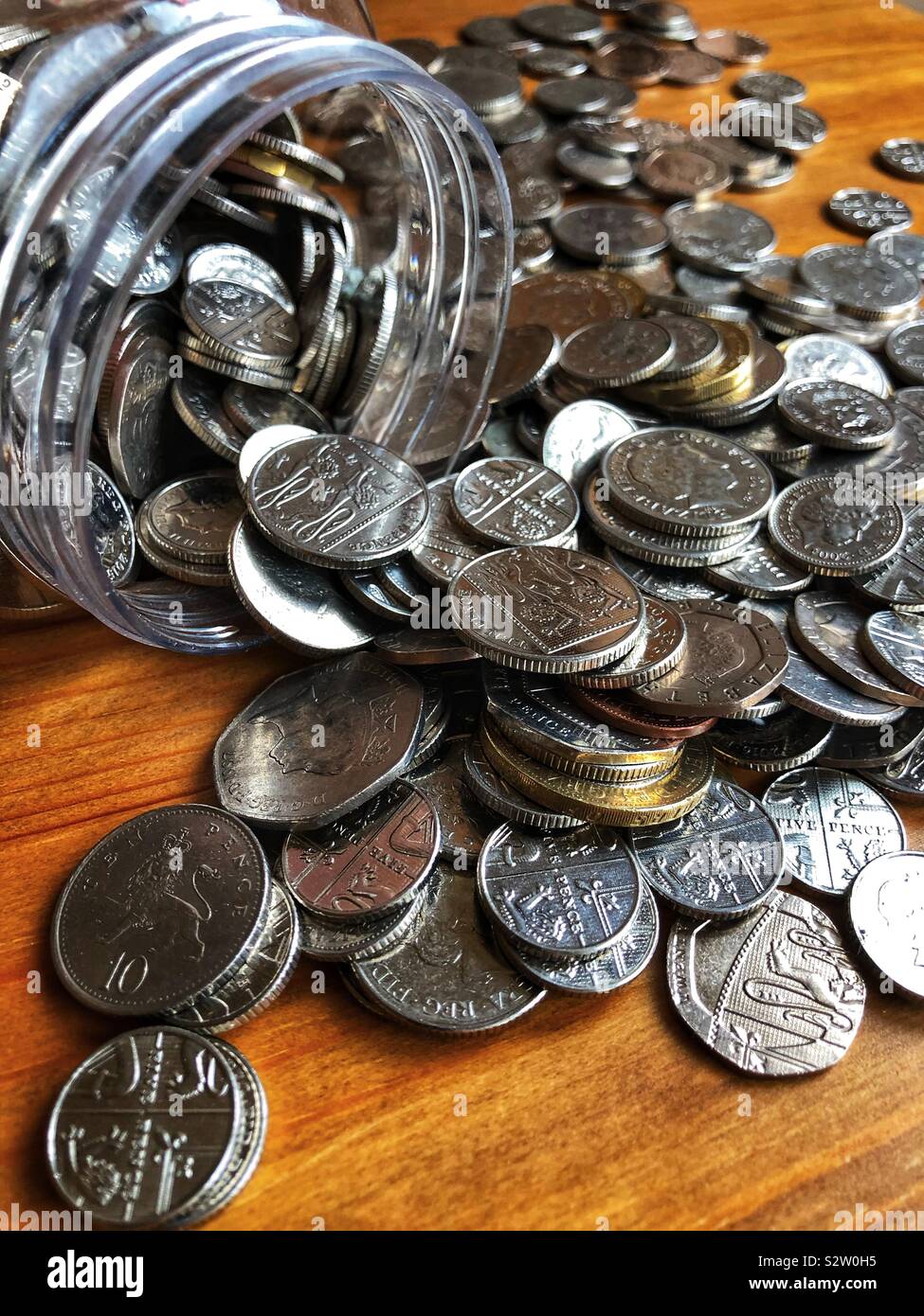 Geld Verschütten von Einsparungen jar - Smartphone-aufgenommenes Stockfoto